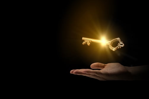 Close up of human hand holding golden key-1