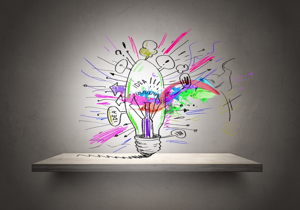 Conceptual image of light bulb on wall with sketches of ideas